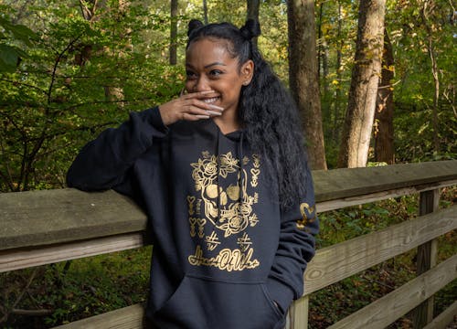 A Woman in a Jacket Leaning on a Wooden Fence