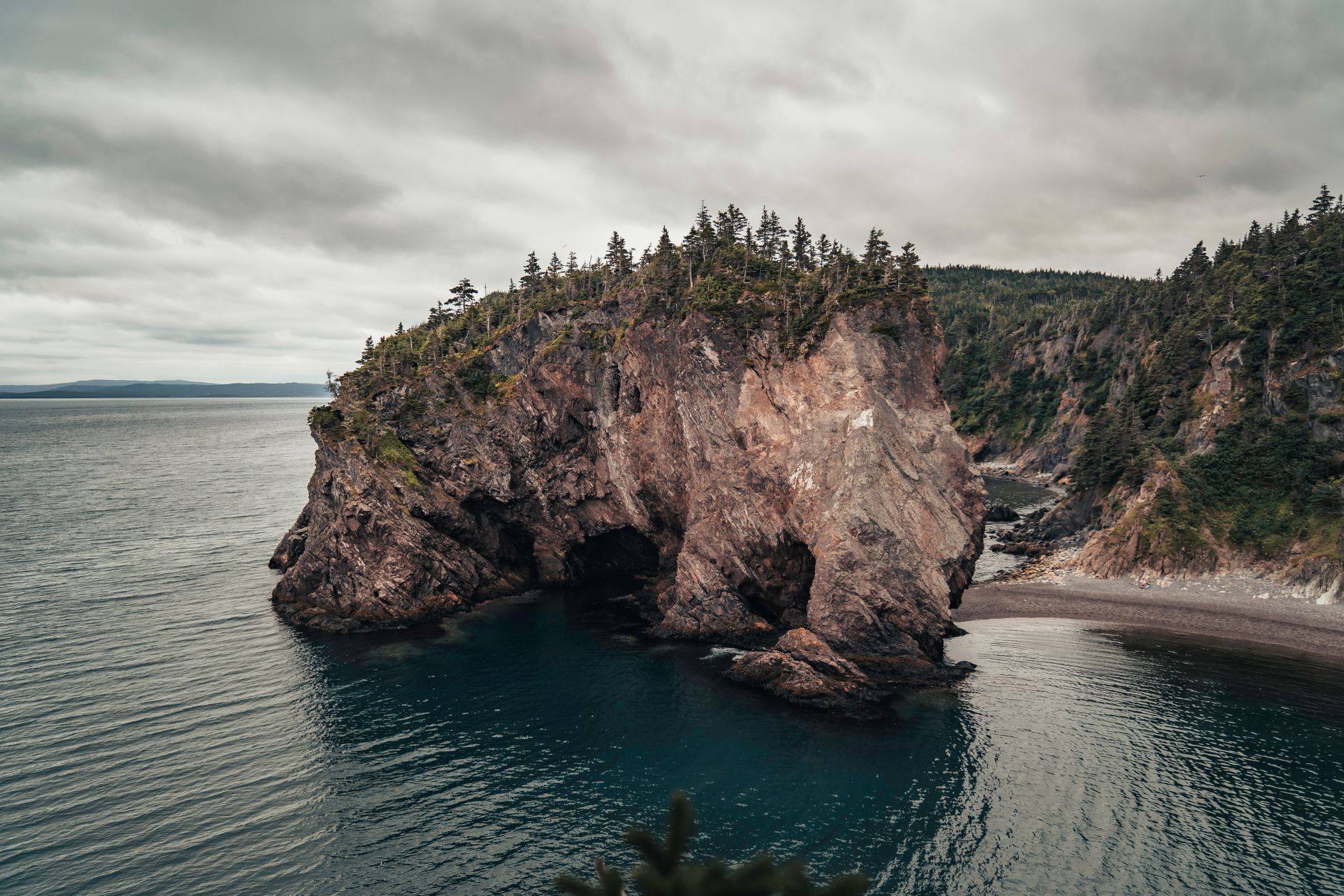 Dramatic coastal rock formation at Chance Cove, Newfoundland and Labrador, under cloudy skies.