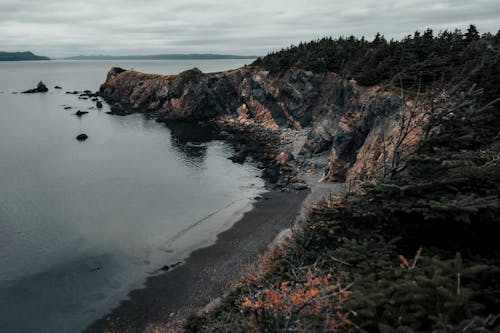 Brown Rocky Mountain Beside Body of Water