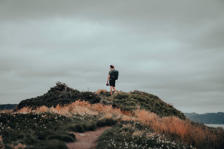 Man Standing On Top Of Hill