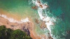 从空中俯瞰巴西热带海滩，碧绿的海水与郁郁葱葱的植被尽收眼底