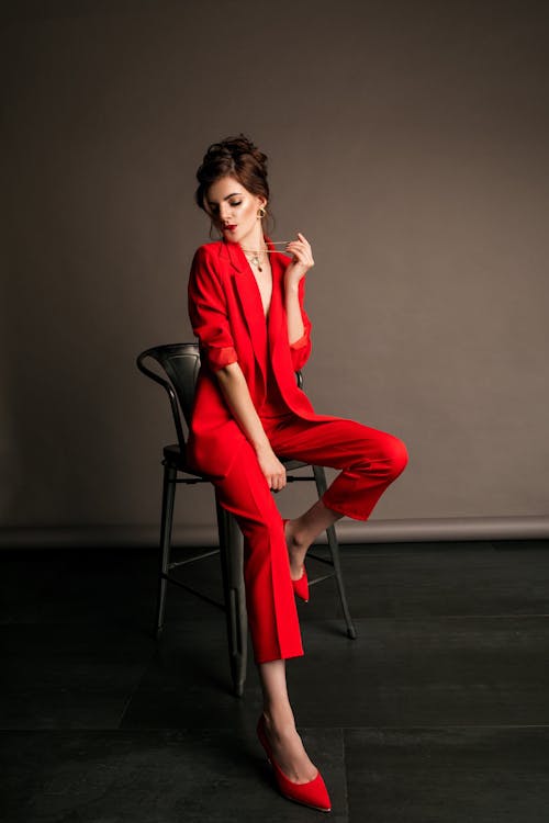 Woman in Red Suit Sitting on Chair