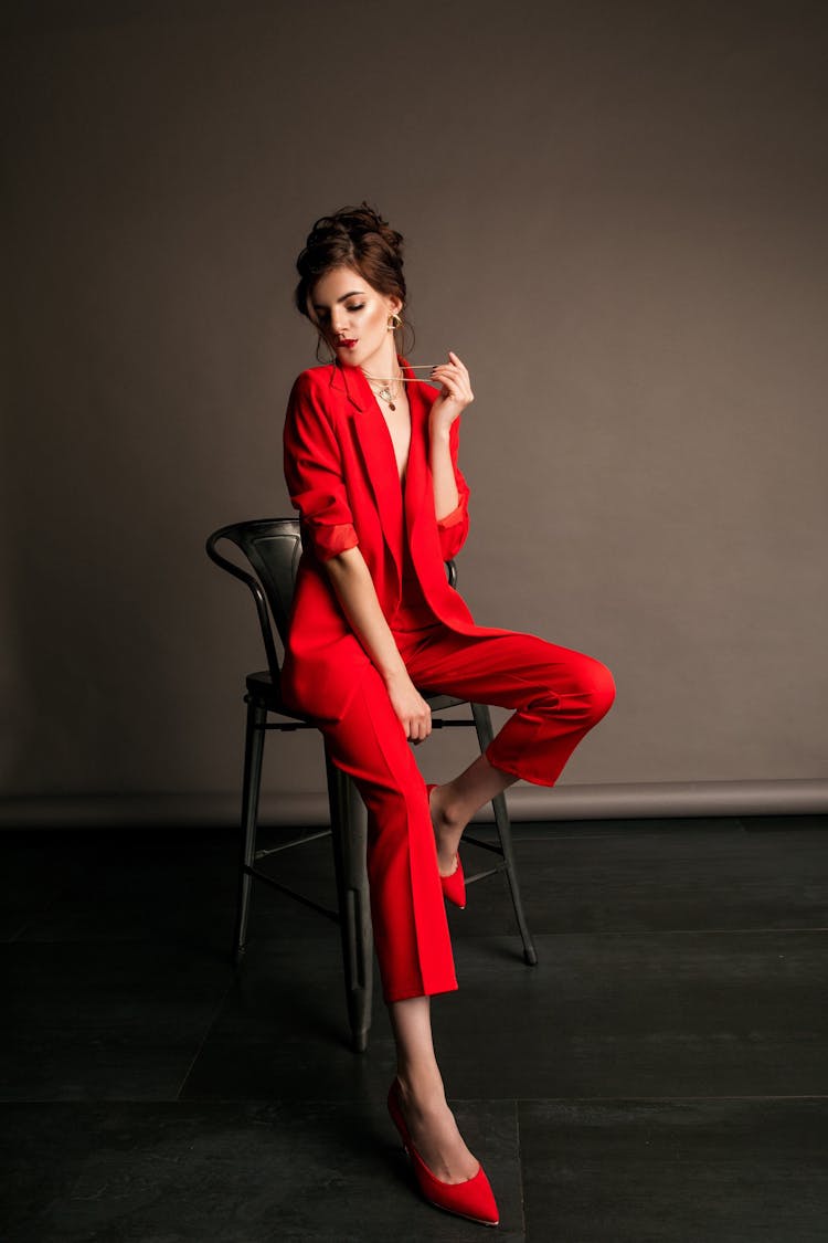 Woman In Red Suit Sitting On Chair