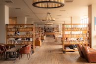 Warm and inviting library interior in Stepantsminda, Georgia with wooden bookshelves and leather chairs.