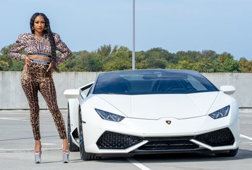 A Beautiful Woman Standing Beside the Luxury Car