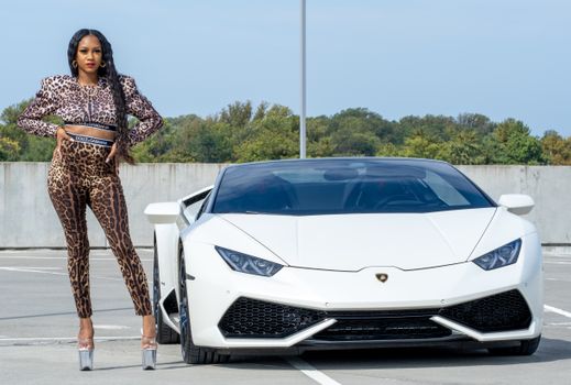 A Beautiful Woman Standing Beside the Luxury Car
