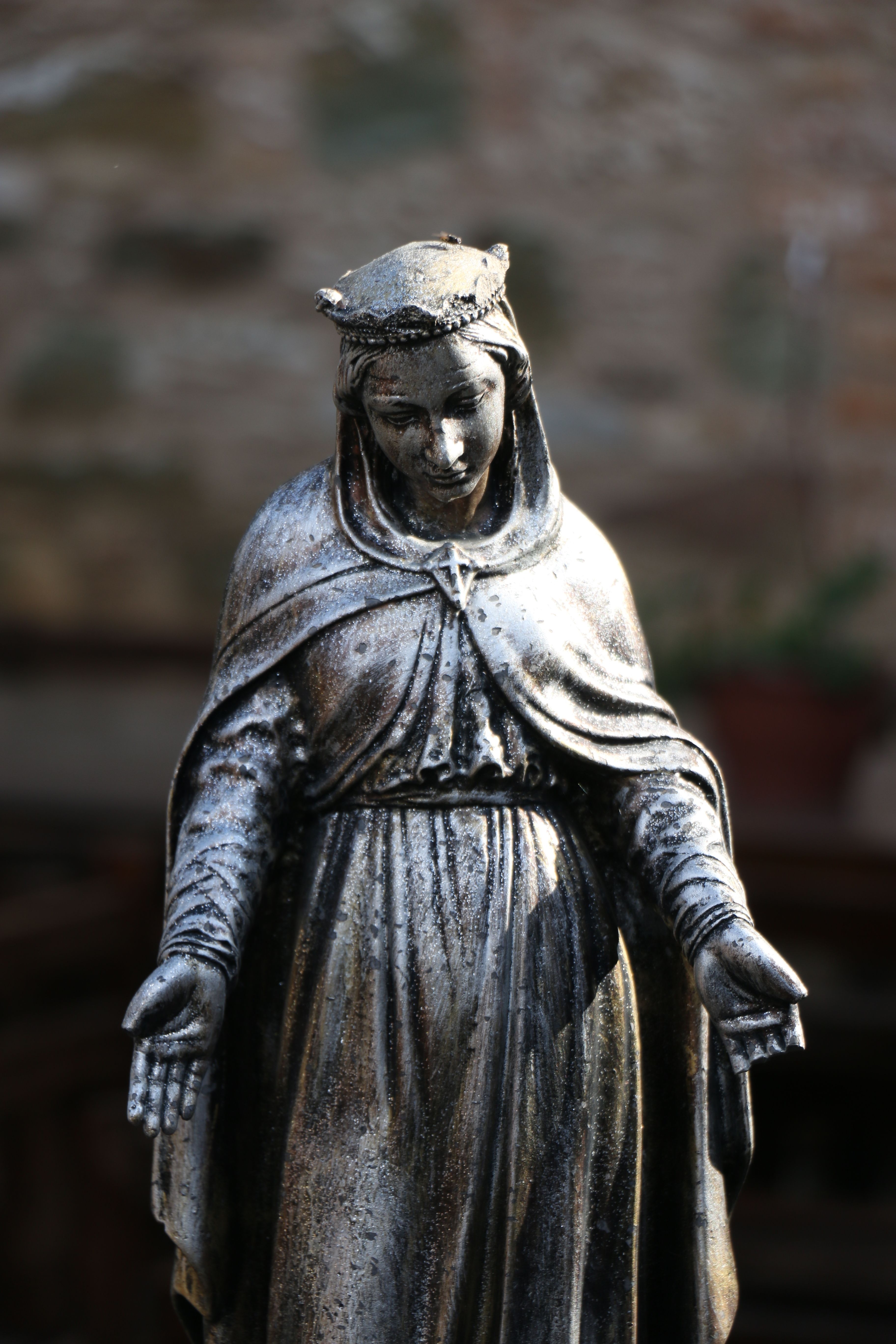A detailed brass religious statuette captured with a shallow focus, showcasing its intricate design.