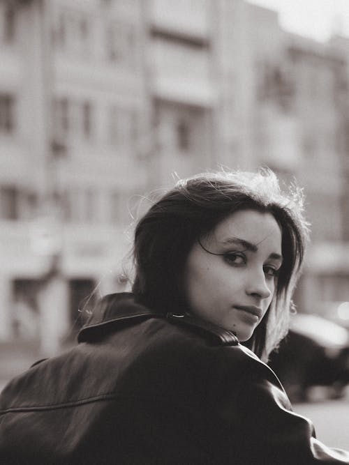 Teenage Girl in Street Wearing Leather Jacket Looking Back at Camera