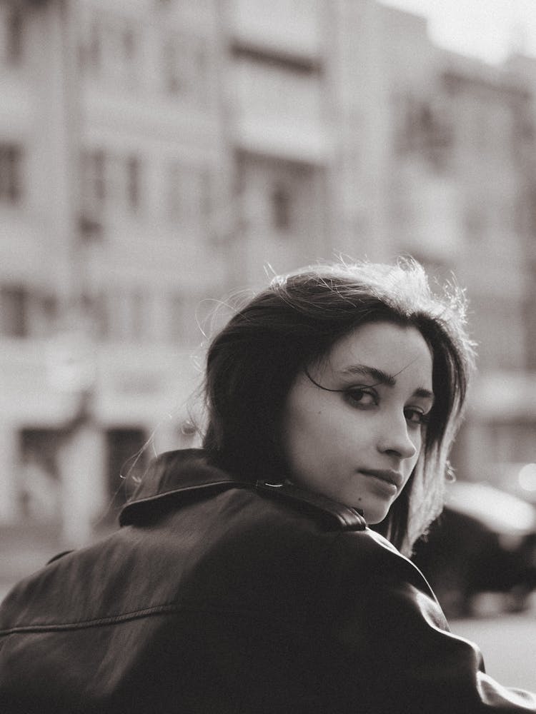 Teenage Girl In Street Wearing Leather Jacket Looking Back At Camera