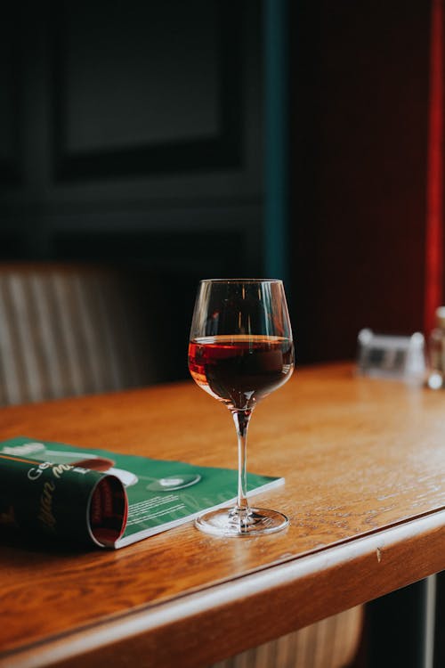 Glass of Red Wine and Magazine on Table