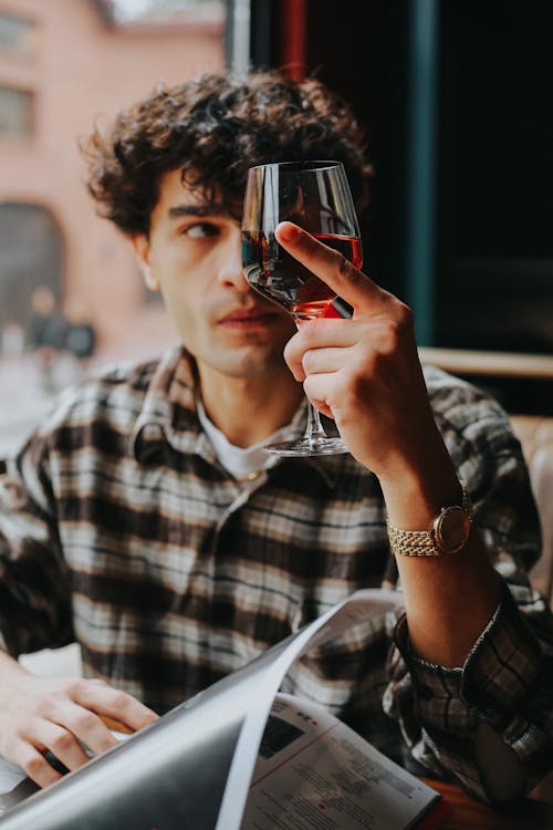 Man Holding Glass of Red Wine in Restaurant