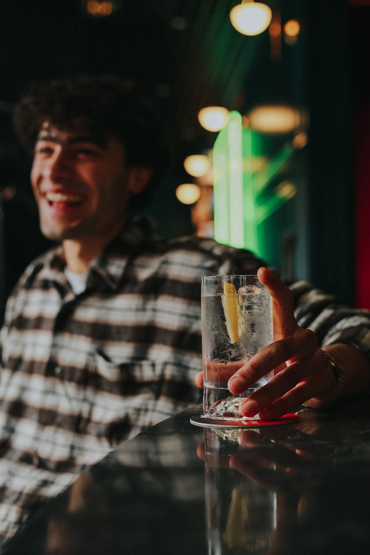 Man Holding Glass Of Water With Lemon Slice 