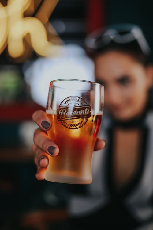 Close-up of Womans Hand Holding Glass of Beer
