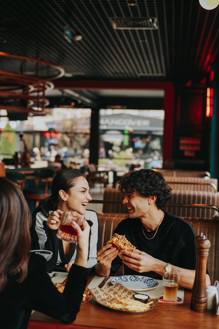 Friends Eating And Drinking In Restaurant