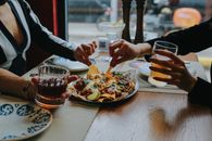Close-up of Friends Sharing Food at Restaurant Table