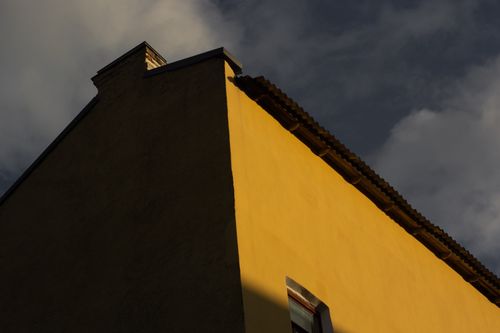 Free Dramatic low angle photo of a building's exterior against a cloudy sky at sunset. Stock Photo