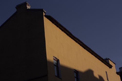Free Dramatic low angle view of a building facade with deep shadows against a clear sky. Stock Photo
