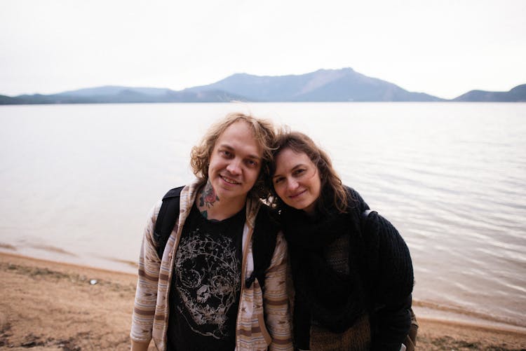 Couple Posing For Souvenir Photo At Beach On Lake