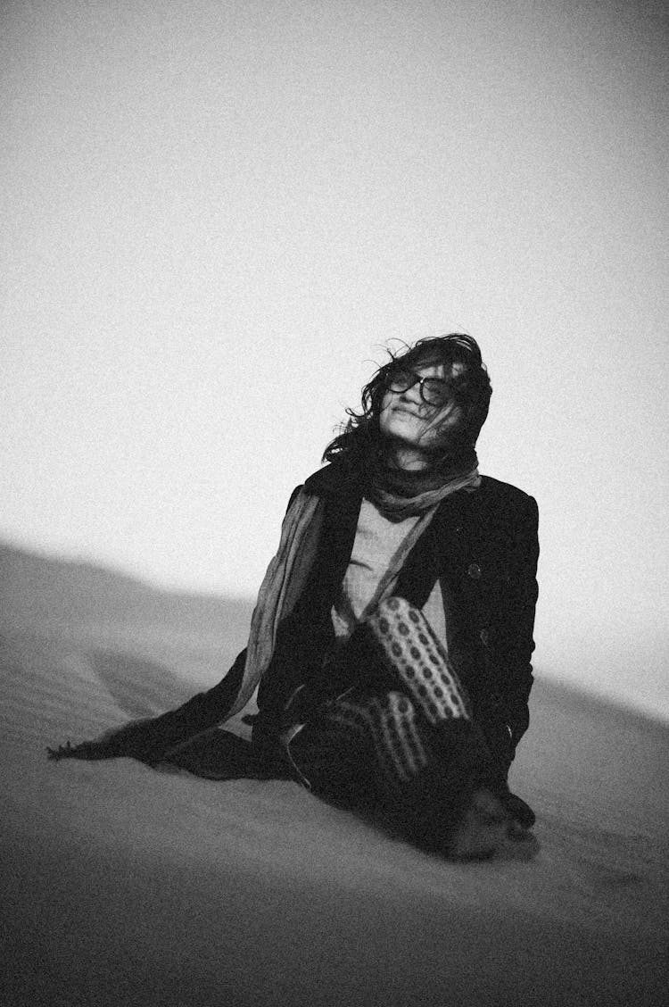 Artistic Photo Of Woman In Specs Sitting On Sand