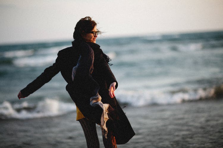 Woman With Arms Outstretched On Beach