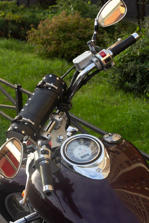 Free Close-up view of a vintage motorcycle's handlebar and gauges, showcasing intricate design. Stock Photo