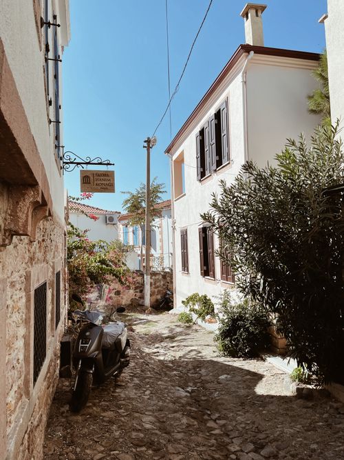 Free A picturesque cobblestone alley in Balıkesir, Türkiye, with vintage architecture and a parked motorbike. Stock Photo