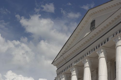Free Low angle view of a classical architecture building with columns against a cloudy blue sky. Stock Photo