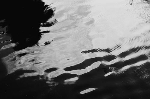 Free Monochrome image capturing abstract reflections on rippling water surface. Stock Photo