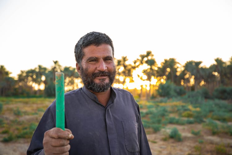 Man Holding A Wooden Pole