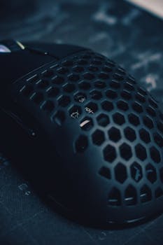 Close-up of a sleek black gaming mouse featuring a unique honeycomb pattern for ventilation and style.