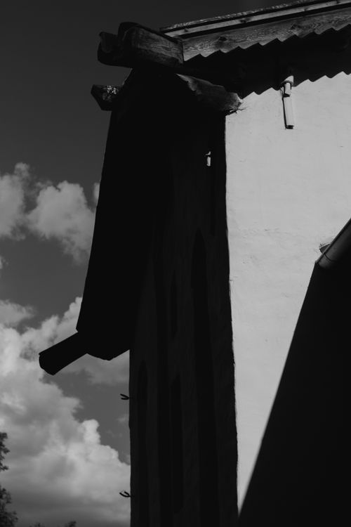 Free A striking black and white image of a building's shadow against a cloudy sky. Stock Photo