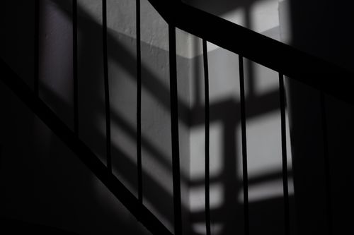 Free Moody abstract image of staircase shadows creating geometric patterns on walls. Stock Photo