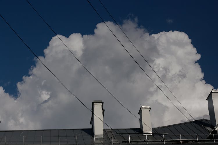 Fluffy White Cloud Over House Rooftop