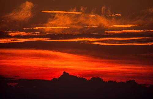 Free Captivating red and orange sunset with silhouetted clouds in Minnesota's scenic horizon. Stock Photo