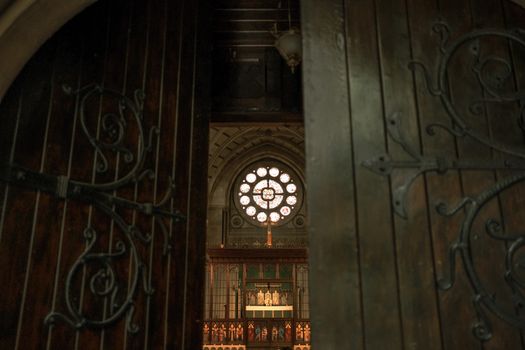 A low-angle view through open church doors, revealing a beautifully ornamented interior.
