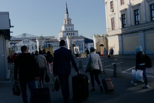 A Group of Tourist Walking on the Street with Their Luggages