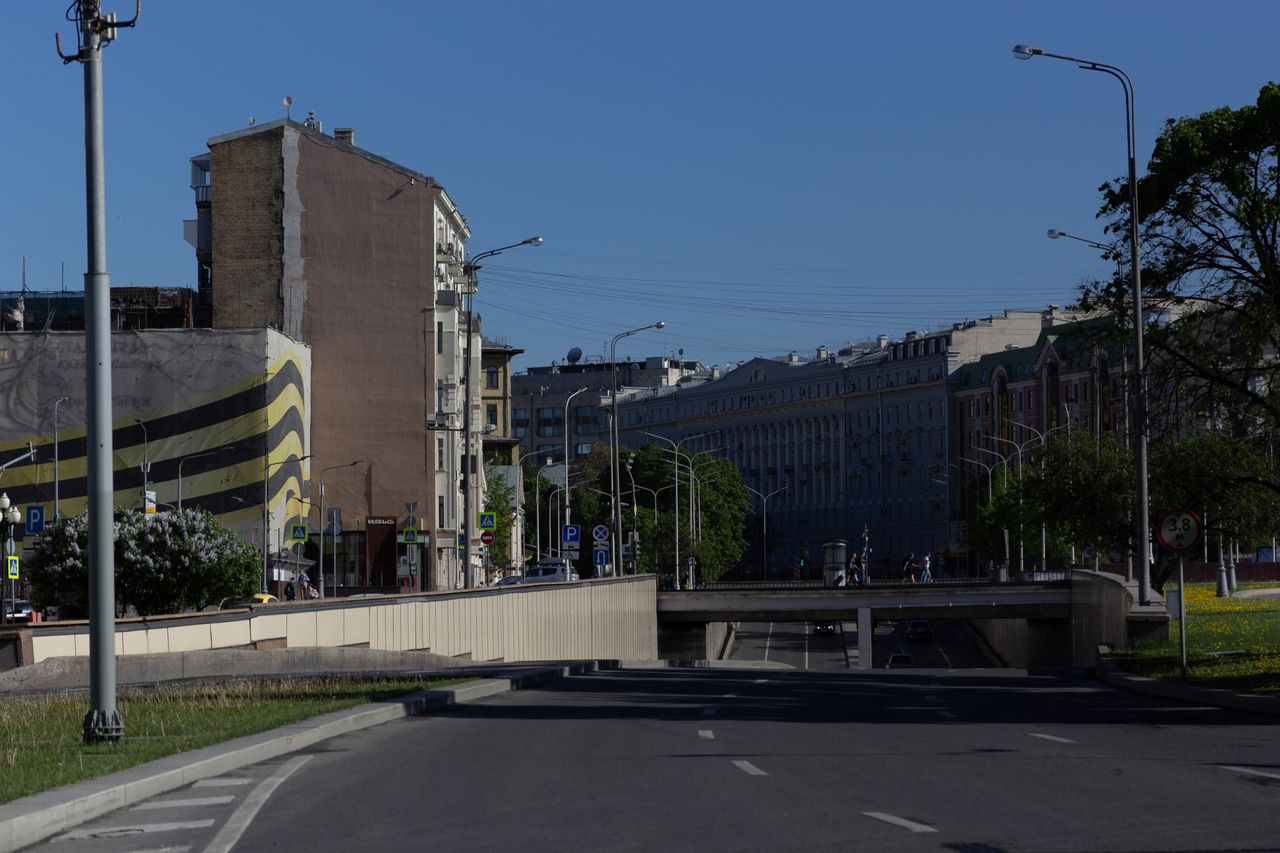 a clear day cityscape featuring an empty road and distinctive building