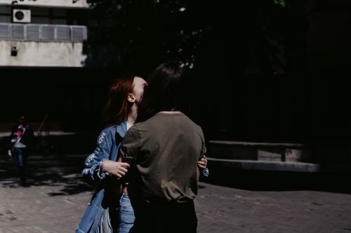 Free Two individuals sharing a hug in an urban outdoor setting, capturing a candid moment. Stock Photo
