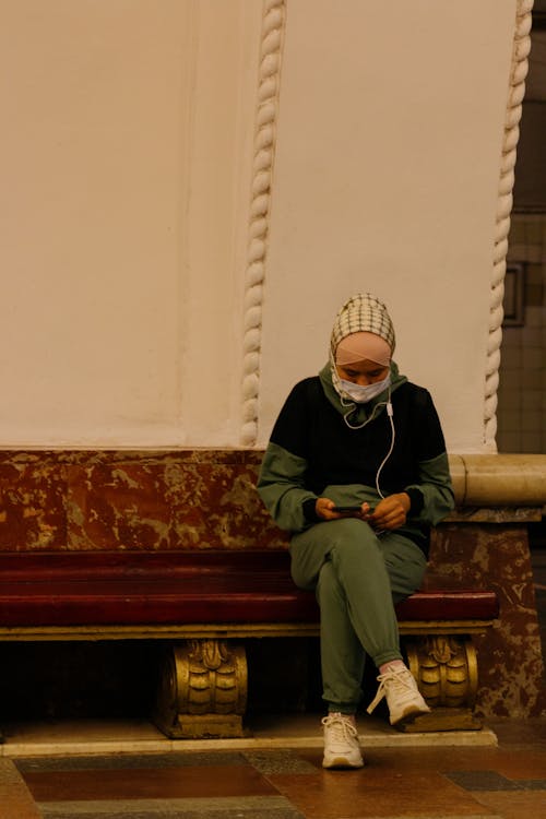 Woman Wearing Headscarf and Face Mask Sitting