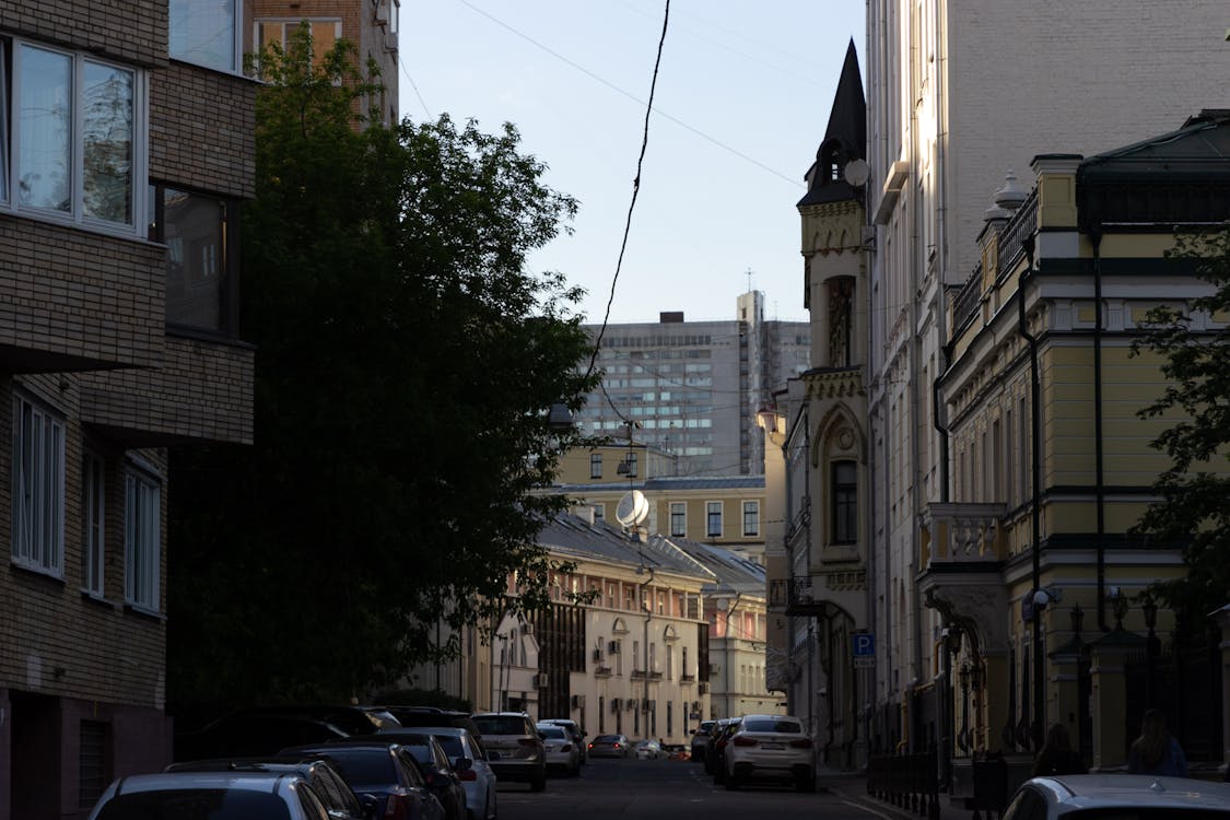 Cars Parked in the Street Between Buildings