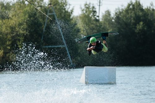 Free A thrilling wakeboarding stunt captured mid-air over a lake, showcasing dynamic motion and energy. Stock Photo