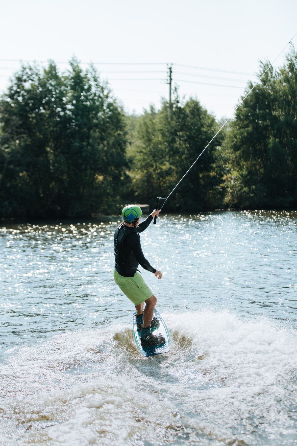 Wakeboarder riding across a sunny lake