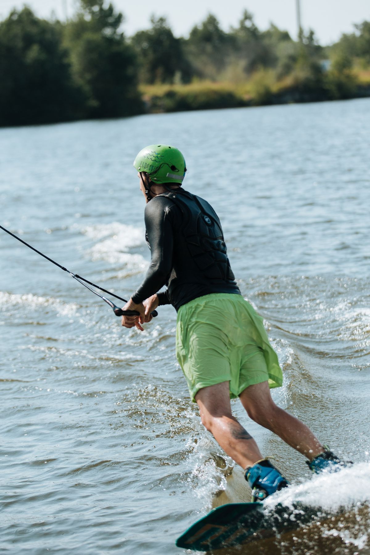 Wakeboarder riding away from the camera on a lake