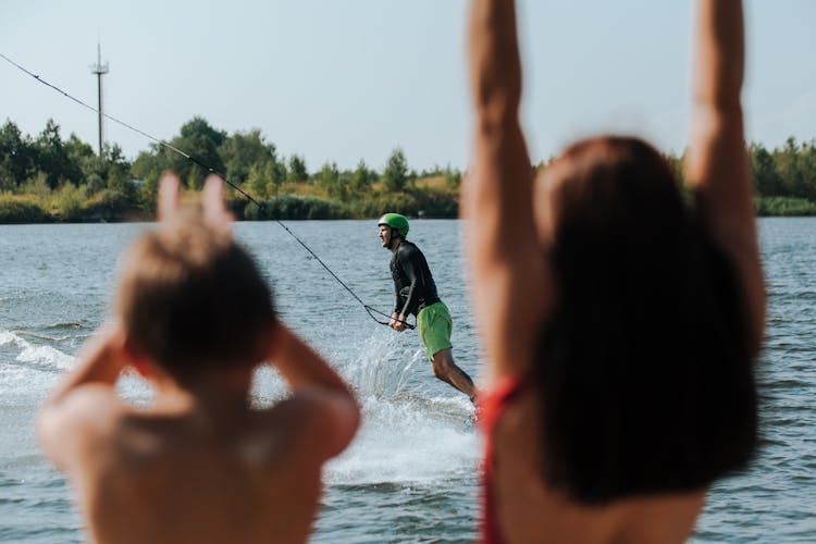 Mother And Son Watching Wake Boarding And Cheering