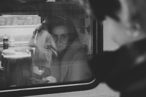 Free A woman looks through a train window in a black and white scene, reflecting a contemplative mood. Stock Photo
