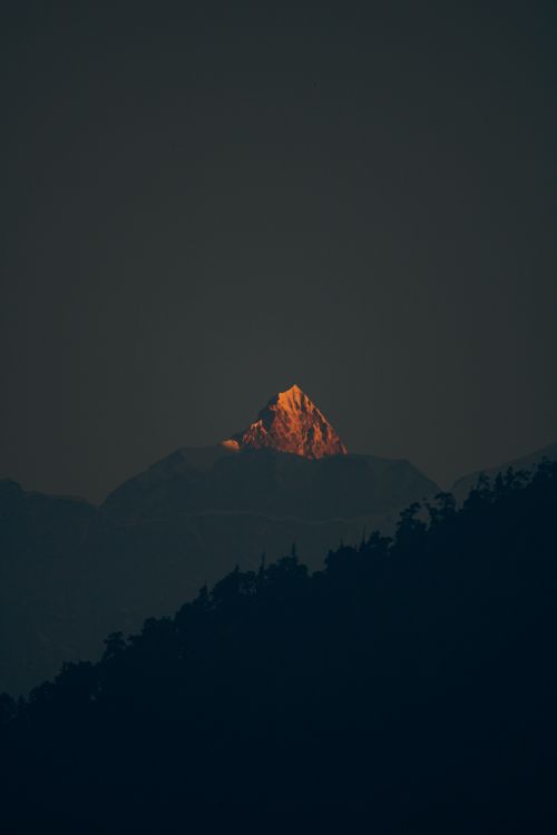 Free Dramatic view of a sunlit mountain peak in Auli, Uttarakhand during dusk. Stock Photo