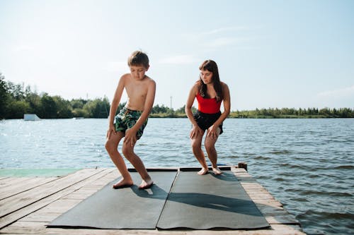 Mother and Son Doing Exercises on Jetty