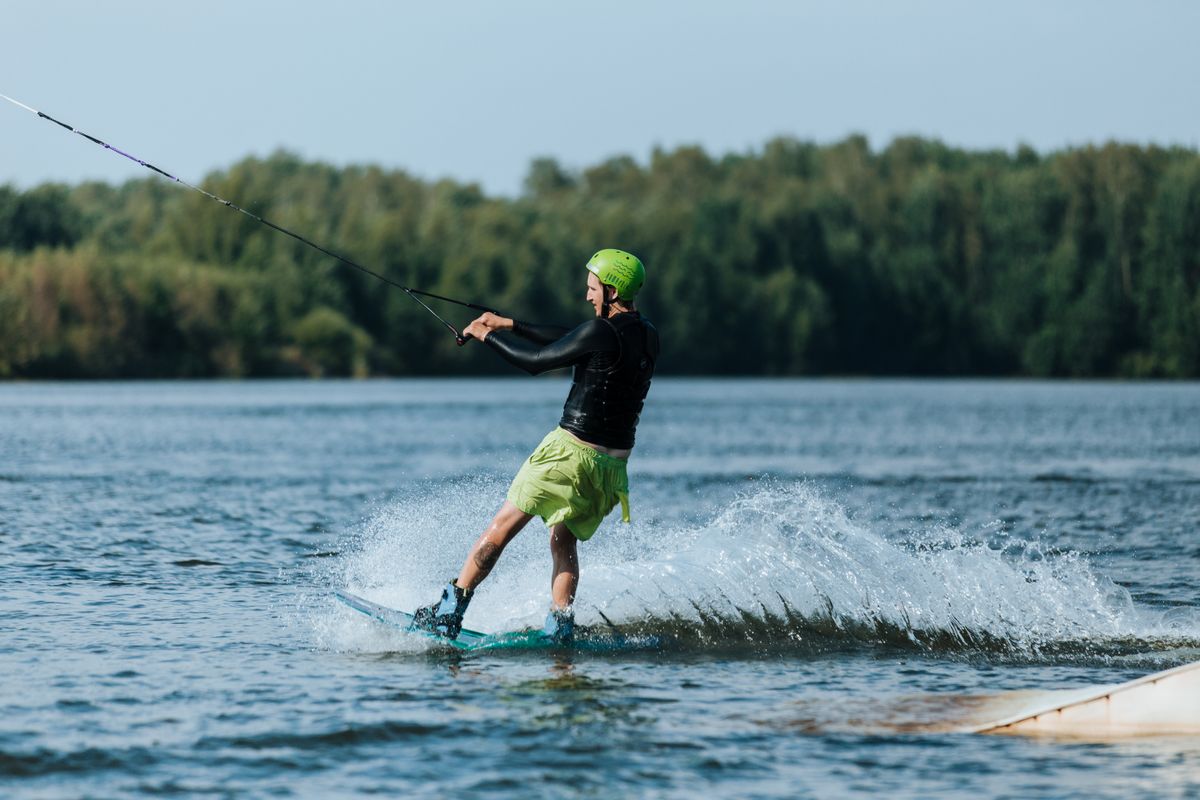 Wakeboarder riding across a sunny lake
