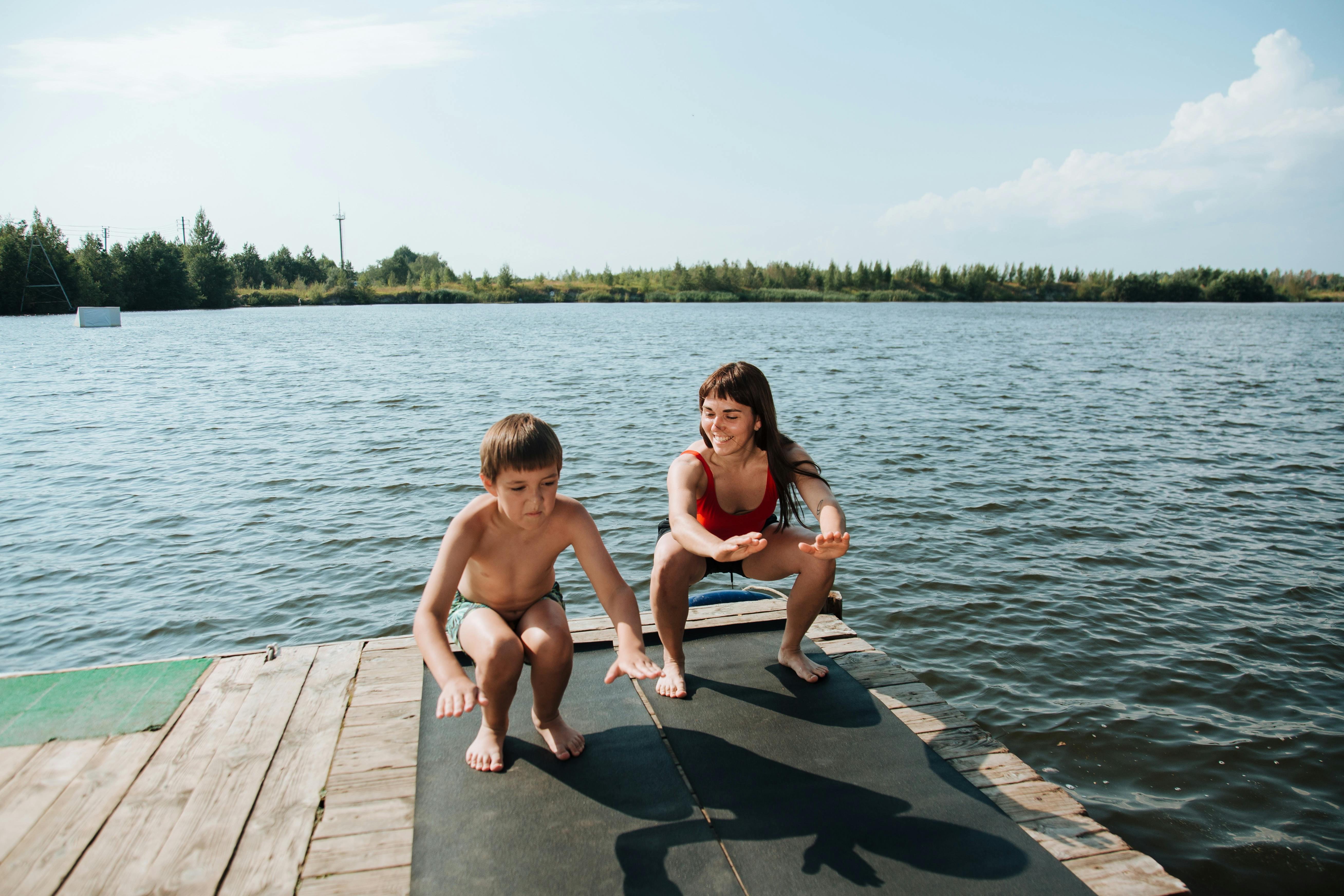 mother and son exercising on jetty