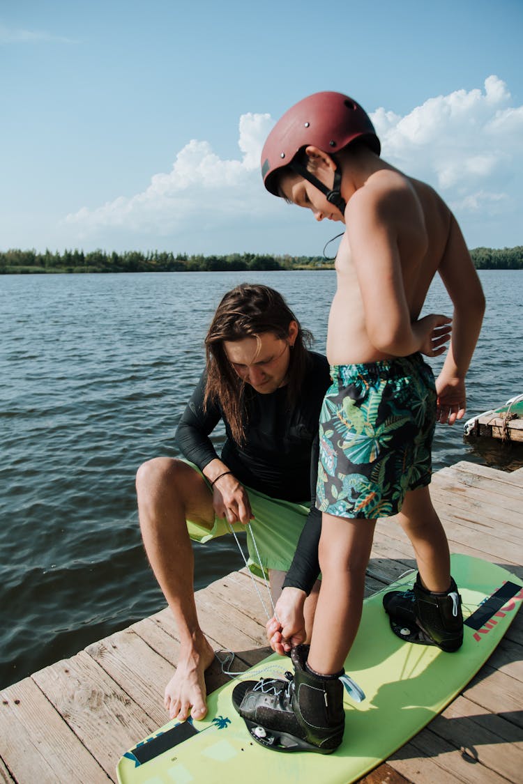 Father Helping Son Before Wakeboarding